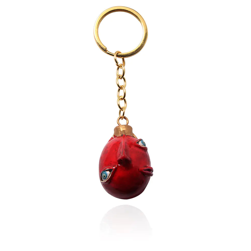 Windblade Pendant - Red face-shaped keychain with a gold chain  